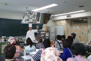 昔ながらのあらびきポークウインナー持つシェフ